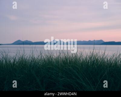 Vista dell'orizzonte dell'Isola di Skye dalla penisola di Applecross - paesaggio dell'isola di mare al crepuscolo, West Highlands, Scozia Regno Unito - erba di Marram Foto Stock