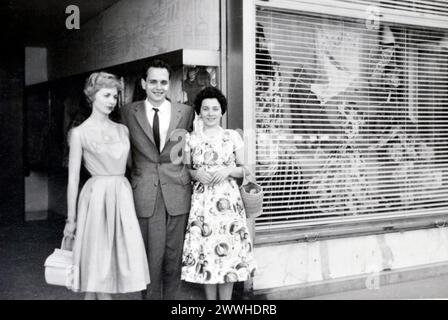 Elegante giovane coppia e amica donna all'aperto appoggiata sul muro sotto l'albero alla fine degli anni '1950 o all'inizio degli anni '1960 in Germania Foto Stock