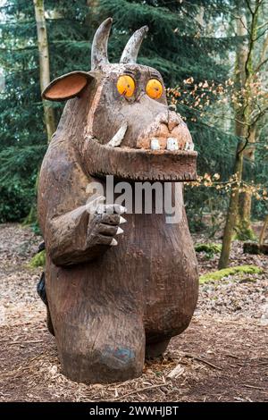 Una statua scolpita del personaggio gruffalo dei bambini in un bosco Foto Stock