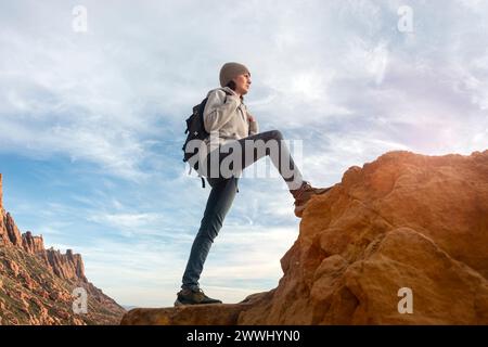 donna escursionista con zaino che cammina su una montagna Foto Stock