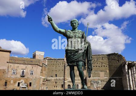 25 febbraio 2024, Roma, Italia. Una statua in bronzo dell'imperatore romano Augusto di fronte alle antiche rovine Foto Stock