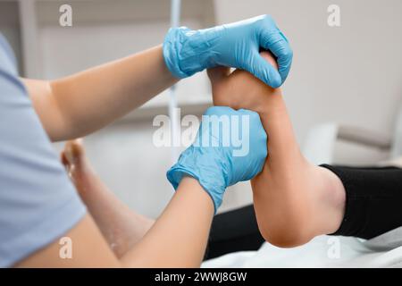 Massaggiatore che effettua un massaggio ai piedi professionale nel salone di bellezza. Foto Stock