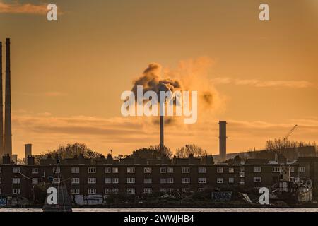 Fumo proveniente dal camino sopra edifici antichi al Grand Canal Dock all'alba di Dublino. Irlanda. Foto Stock