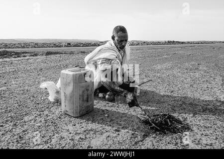 Mauritania, dintorni di M'Hareth, uomo che prepara il tè ai margini di una pista Foto Stock