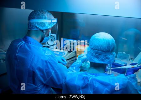 I colleghi assistenti di laboratorio utilizzano un dispenser per pipette nel loro lavoro Foto Stock