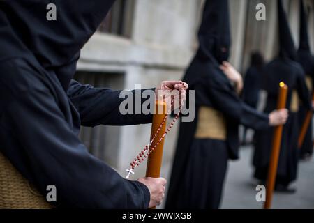 Madrid, Madrid, Spagna. 24 marzo 2024. Penitente dalla fratellanza dei Nazareni del Santissimo Cristo della fede, protegge la fiamma della sua candela con la mano durante, il passaggio processionale dell'immagine del Santo Cristo della fede e il perdono della Basilica di San Miguel nel suo viaggio attraverso le strade di Madrid. (Immagine di credito: © Luis Soto/ZUMA Press Wire) SOLO PER USO EDITORIALE! Non per USO commerciale! Crediti: ZUMA Press, Inc./Alamy Live News Foto Stock