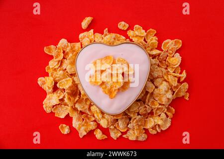 Cuore con yogurt e cereali in fiocchi di mais zuccherati Foto Stock