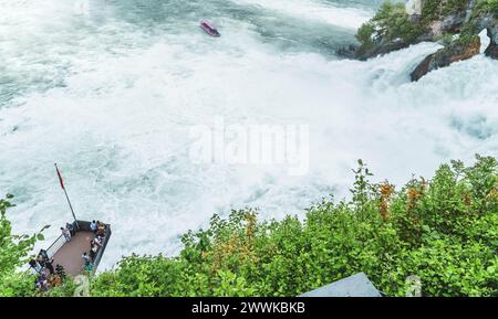 Descrizione: I turisti possono ammirare le imponenti cascate sotto il castello di Laufen presso le cascate del Reno dalla piattaforma panoramica e dalla barca turistica. Cascate del Reno Foto Stock