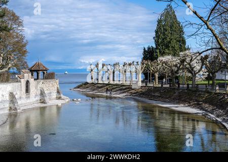 Beschreibung: Touristen genießen einen sonnigen Frühlingstag im blühenden Stadtgarten am Kanal zum Steigenberger Hotel. Costanza, Bodensee, Baden-Würt Foto Stock