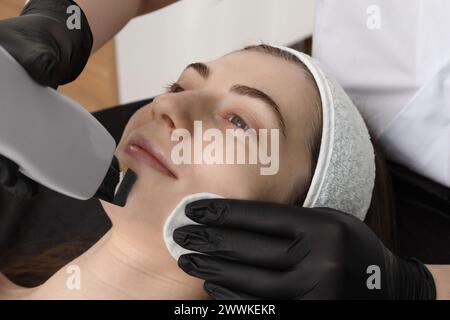 Cosmetologo che utilizza lo scrubber a ultrasuoni, primo piano. Cliente con procedura di pulizia in ambienti chiusi Foto Stock