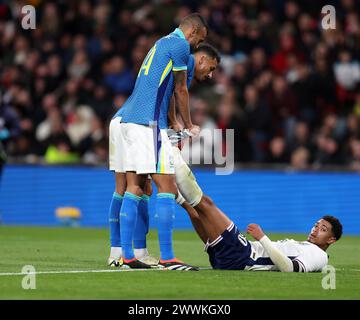 Londra, Regno Unito. 23 marzo 2024. Danilo e Fabricio Bruno del Brasile (14) aiutano Jude Bellingham d'Inghilterra mentre si trova a terra soffrendo di crampi. Inghilterra contro Brasile, partita amichevole internazionale di calcio allo stadio Wembley di Londra sabato 23 marzo 2024. Solo per uso editoriale. foto di Andrew Orchard/Andrew Orchard fotografia sportiva/Alamy Live News Credit: Andrew Orchard fotografia sportiva/Alamy Live News Foto Stock