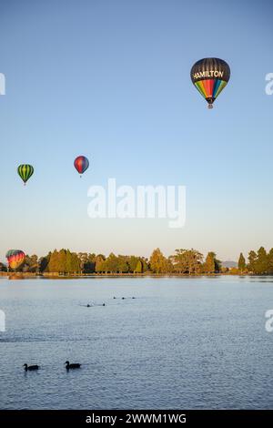 Hamilton, nuova Zelanda, 14 marzo 2023: Mongolfiere su Waikato all'alba, vista dall'altra parte del lago Foto Stock