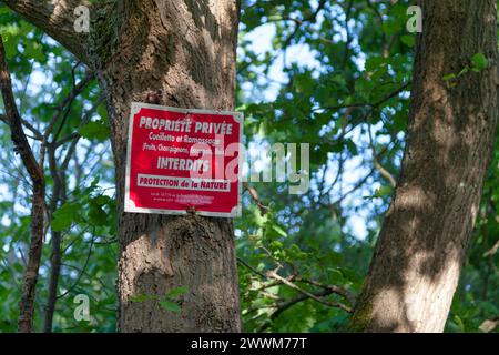 Un cartello con scritto in francese "Propriété privée - Cueillette et ramassage (frutta, champignons, escargots, bois) interdits - protezione Foto Stock