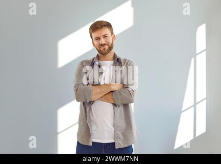 Ritratto di un uomo attraente sorridente in piedi con le braccia incrociate Foto Stock