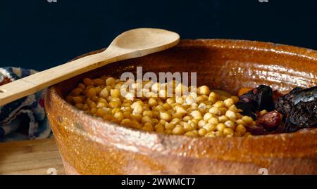 Una ciotola di argilla con ceci e carne, pronta per un tipico stufato di Madrid Foto Stock