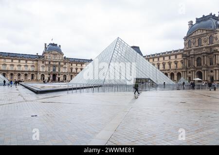 5 dicembre 2023 - turisti fuori dalla Piramide di vetro all'ingresso del Museo del Louvre a Parigi, Francia Foto Stock