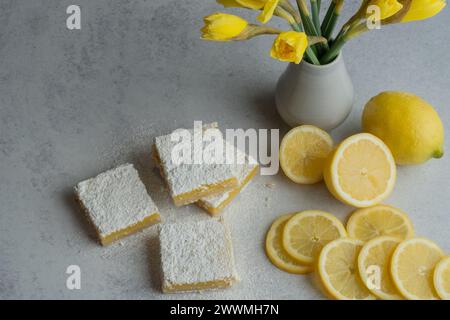 Natura morta con limoni, quadrati di limoni e narcisi gialli. Foto Stock