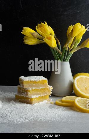 Natura morta con limoni, quadrati di limoni e narcisi gialli. Foto Stock