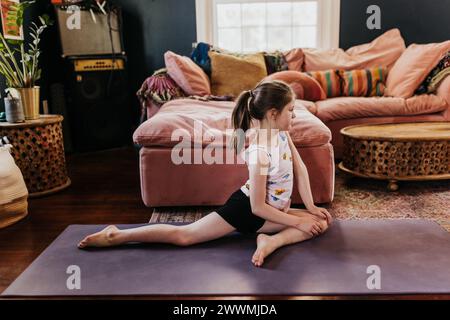 Vista laterale di una ragazza che fa posa al piccione nel soggiorno Foto Stock