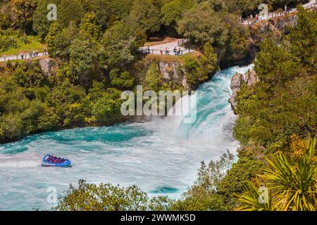 Un gruppo di persone in piedi e che guardano su una motoscafo alle cascate Huka, una serie di cascate sul fiume Waikato, che drena il lago Taupo, sul Nort Foto Stock
