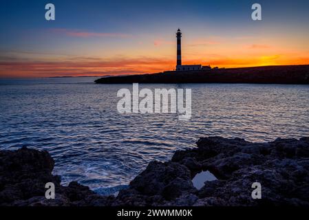 Faro di Artrutx al tramonto invernale a capo Cap d'Artrutx (Minorca, Isole Baleari, Spagna) ESP: Faro de Artrutx en un atardecer de invierno Foto Stock