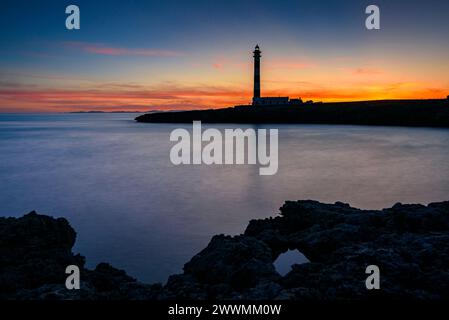 Faro di Artrutx al tramonto invernale a capo Cap d'Artrutx (Minorca, Isole Baleari, Spagna) ESP: Faro de Artrutx en un atardecer de invierno Foto Stock