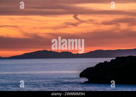 Montagne orientali dell'isola di Maiorca viste da Capo Cap d'Artrutx, a Minorca, al tramonto invernale (Minorca, Isole Baleari, Spagna) Foto Stock