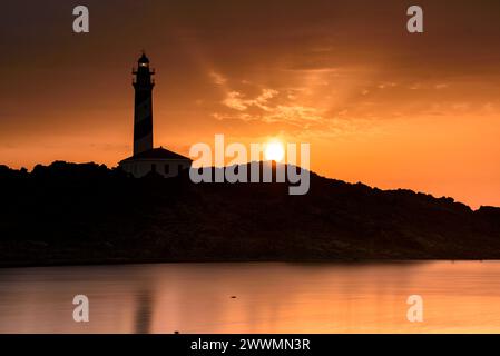 Alba al faro di Favàritx con riflessioni sullo stagno temporaneo di es Cos des Síndic (Minorca, Isole Baleari, Spagna) Foto Stock