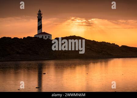 Alba al faro di Favàritx con riflessioni sullo stagno temporaneo di es Cos des Síndic (Minorca, Isole Baleari, Spagna) Foto Stock