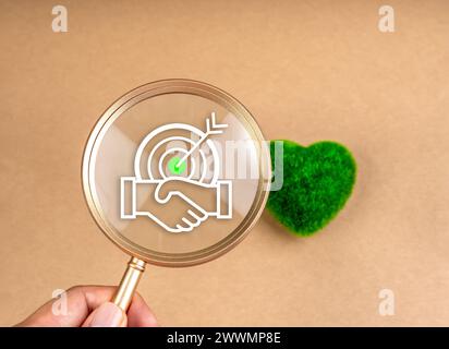 Green Life società membri della comunità sostenibilità, concetto di responsabilità ambientale. Icona obiettivo cooperazione di successo in lente di ingrandimento con Foto Stock