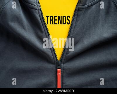 Cerniera aperta di una felpa con cappuccio che mostra le tendenze della parola su un tag. Tendenze della moda nell'abbigliamento sportivo casual. Foto Stock