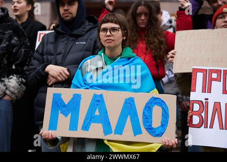 Patriota ucraino che posa con lo striscione "non abbastanza" su una manifestazione per l'aumento del bilancio militare delle forze armate dell'Ucraina. Kiev - 23 marzo 2024 Foto Stock