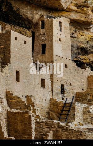 Una vista dettagliata dell'architettura pueblo secolare, che mostra l'intricata lavorazione in pietra annidata in una parete rocciosa Foto Stock