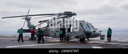 PACIFIC OCEAN (23 febbraio 2024) i marinai assegnati all'Helicopter Sea Combat Squadron (HSC) 25, conducono la manutenzione su un elicottero MH-60S a bordo della portaerei d'assalto anfibio schiata in avanti USS America (LHA 6) mentre conducono operazioni di routine nell'Oceano Pacifico, il 23 febbraio. L'America, nave di comando dell'America Amphibious Ready Group, è operativa nell'area operativa della 7th Fleet. La U.S. 7th Fleet è la più grande flotta numerata della Marina degli Stati Uniti, e interagisce e opera regolarmente con alleati e partner nel preservare una regione indo-pacifica libera e aperta. Marina Foto Stock