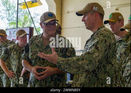 Apra HARBOR, Guam (7 febbraio 2024) – il tenente Millard Joseph, l'ufficiale d'armi a bordo del sottomarino classe Emory S. Land USS Frank Cable (AS 40), parla con il contrammiraglio Michael Van Poots, vice comandante della forza sottomarina Atlantic/vice comandante della forza sottomarina Pacific, 7 febbraio 2024. Frank Cable, schierato in avanti sull'isola di Guam, ripara, riarma e rifornisce sommergibili e navi di superficie nella regione Indo-Pacifico. Marina Foto Stock