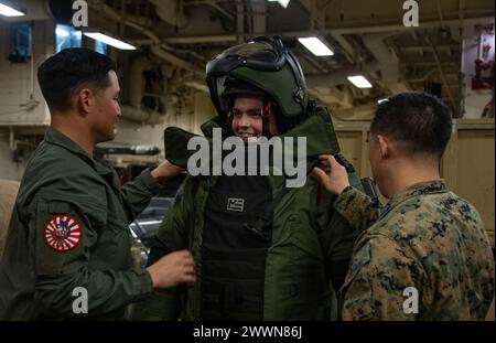 PACIFIC OCEAN (17 febbraio 2024) Specialista culinario di seconda classe Nathan Bouchard, centro, di Katy, Texas, assegnato al vettore d’assalto anfibio schiato in avanti USS America (LHA 6), prova una tuta antibomba durante una dimostrazione di smaltimento di ordnance esplosive (EOD) nella zona di stoccaggio dei veicoli della nave, durante le operazioni di routine nell'Oceano Pacifico, il 17 febbraio. L'America, nave di comando dell'America Amphibious Ready Group, è operativa nell'area operativa della 7th Fleet. La U.S. 7th Fleet è la più grande flotta numerata della Marina degli Stati Uniti, e interagisce di routine e opera con gli alleati e. Foto Stock
