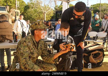 240204-N-GA645-1037 STAZIONE NAVALE DI ROTA, Spagna (4 febbraio 2024) Un marinaio assegnato all'Explosive Ordnance Disposal Mobile Unit (EODMU) 8 aiuta un bambino a utilizzare un robot tattico durante un evento di coinvolgimento della comunità presso la fiera Rota, 4 febbraio 2024. NAVSTA Rota è un moltiplicatore di forze, in grado di dispiegare e sostenere prontamente forze pronte al combattimento attraverso terra, aria e mare, consentendo ai combattenti e alle loro famiglie, sostenendo la flotta e favorendo la partnership tra Stati Uniti e Spagna. Marina Foto Stock