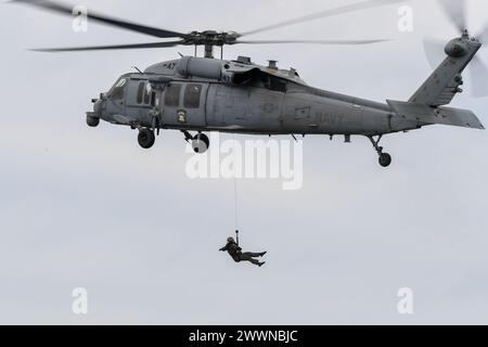 Un MH-60S Seahawk dell'Helicopter Sea Combat Squadron 23 "wildcard" esegue operazioni di recupero durante il Recovery test 11, 25 febbraio 2024. In preparazione della missione Artemis II della NASA, che invierà quattro astronauti a Orion oltre la Luna, la NASA e il Dipartimento della difesa condurranno una serie di test per dimostrare e valutare i processi, le procedure e l'hardware utilizzati nelle operazioni di recupero per le missioni lunari con equipaggio. I moli di trasporto anfibi, come la USS San Diego, hanno capacità uniche che la rendono un partner ideale per sostenere la NASA, tra cui l'imbarco di elicotteri, l Foto Stock