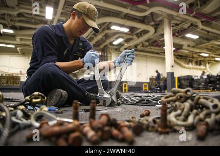 240212-N-VR794-1132 SAN DIEGO (12 febbraio 2024) – il Seaman James Chang, da Los Angeles, smonta le catene per la ristrutturazione nell'area di stivaggio dei veicoli a bordo della portaerei d'assalto anfibio USS Tripoli (LHA 7), 12 febbraio. Tripoli è una nave d'assalto anfibia di classe americana portata a San Diego. Marina Foto Stock