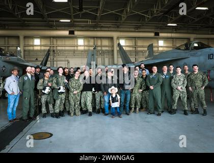 VIRGINIA BEACH, Virginia (23 febbraio 2024)- i Professional Bull Riders (PBR) Andrew Alvidrez e Brandon Chandler posano per una foto di gruppo con lo Strike Fighter Squadron (VFA) 37 “Ragin’ Bulls” e il pilota tenente cmdr. Il figlio di Sam Dulaney, Charlie, è stato l'ispirazione per chiamare gli F/A-18E Super Hornets dello squadrone in onore dei tori di PBR, a bordo della Naval Air Station Oceana. I Ragin' Bulls tornarono il 16 gennaio da uno schieramento di otto mesi a sostegno di partner e alleati nella 6th Fleet della Marina degli Stati Uniti d'America nell'area delle operazioni a bordo della USS Gerald R. Ford (CVN 78). Marina Foto Stock
