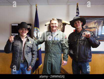 VIRGINIA BEACH, Virginia (FEB. 23, 2024) - i Professional Bull Riders (PBR) Andrew Alvidrez (sinistra) e Brandon Chambers (destra) sono presentati con le monete di sfida di comando dello Strike Fighter Squadron (VFA) 37 “Ragin’ Bulls” comandante ufficiale Michael Tremel durante la loro visita alle strutture dello squadrone a bordo della Naval Air Station Oceana. I Ragin' Bulls tornarono il 16 gennaio da uno schieramento di otto mesi a sostegno di partner e alleati nella 6th Fleet della Marina degli Stati Uniti d'America nell'area delle operazioni a bordo della USS Gerald R. Ford (CVN 78). Marina Foto Stock