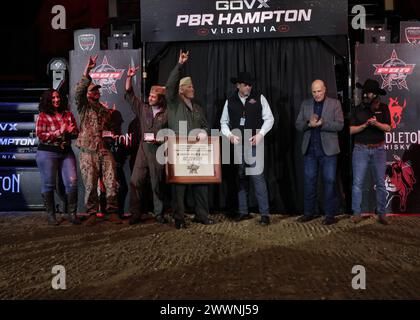 VIRGINIA BEACH, Virginia (23 febbraio 2024)- i Professional Bull Riders (PBR) Andrew Alvidrez e Brandon Chandler posano per una foto di gruppo con lo Strike Fighter Squadron (VFA) 37 “Ragin’ Bulls” e il pilota tenente cmdr. Il figlio di Sam Dulaney, Charlie, è stato l'ispirazione per chiamare gli F/A-18E Super Hornets dello squadrone in onore dei tori di PBR, a bordo della Naval Air Station Oceana. I Ragin' Bulls tornarono il 16 gennaio da uno schieramento di otto mesi a sostegno di partner e alleati nella 6th Fleet della Marina degli Stati Uniti d'America nell'area delle operazioni a bordo della USS Gerald R. Ford (CVN 78). Marina Foto Stock