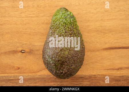 Primo piano foto dettagliata di un avocado nel mezzo di uno snack board di legno. Foto Stock
