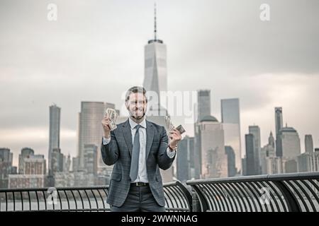Un uomo d'affari ha dei soldi a New York. Uomo d'affari con dollari all'aperto. Ricco uomo d'affari milionario in tuta con soldi. Uomo d'affari maturo Foto Stock