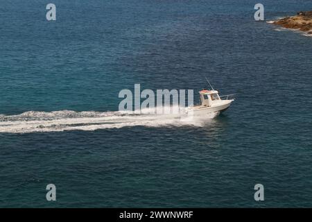 barca a motore bianca, in movimento, di ritorno dal mare verso l'isola di fuerteventura Foto Stock