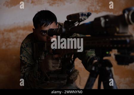 Ryan Jamal-Panuelo, un cecchino di ricognizione della 26th Marine Expeditionary Unit (Special Operations Capable) (MEU(SOC)), guarda attraverso l'ambito di un Barrett Multi Role Adapted Design MK-22 mentre conduce addestramento in battaglia ravvicinato durante un esercizio bilaterale a Massafra, Italia, 24 febbraio 2024. Il 26° MEU(SOC), imbarcato a bordo della USS Mesa Verde (LPD 19), ha condotto un addestramento all'interoperabilità della Task Force aerea-terrestre marina con i Marines italiani della Brigata San Marco e le forze marittime per mantenere la prontezza nei compiti essenziali della missione. Il Bataan Amphibious Ready Group, con emb Foto Stock