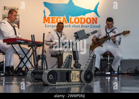 DAYTONA BEACH, Florida - Un tecnico della US Navy Explosive Ordnance Disposal (EOD) dimostra l'equipaggiamento ai membri della comunità locale mentre la Navy Band si esibisce al Daytona Beach Museum of Arts and Sciences come parte della Daytona Beach Navy Week 2024, 16 febbraio 2024. Il Navy Office of Community Outreach ospita settimane della Marina in varie città degli Stati Uniti ogni anno per interagire con il pubblico, mostrare le capacità della marina e partecipare a eventi di relazione con la comunità. Marina Foto Stock