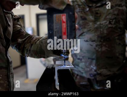 Le guardie nazionali dell'Oklahoma Army usano un trapano mentre competono nella competizione Mechanic of the Year tenutasi presso il Combined Support Maintenance Shop di Norman, Oklahoma, 7 febbraio 2024. Le guardie si sono riunite per mettere alla prova le loro capacità meccaniche nella terza competizione annuale, lavorando in squadre di quattro uomini per battere la concorrenza e anche per entrare in contatto con altri concorrenti. (Oklahoma National Guard Foto Stock