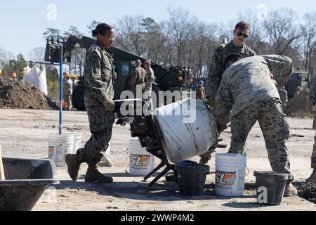 Gli ingegneri di combattimento del corpo dei Marines degli Stati Uniti con l'8th Engineer Support Battalion, 2nd Marine Logistics Group, mescolano cemento per riparare un cratere sull'asfalto dell'aeroporto durante l'esercitazione Winter Pioneer 24, Marine Corps Outlying Field Oak Grove, North Carolina, 15 febbraio 2024. Gli ingegneri del corpo dei Marines degli Stati Uniti e la forza di costruzione della Marina degli Stati Uniti hanno utilizzato il Marine Corps Outlying Field Oak Grove per i Marines e i marinai per provare a creare e sostenere basi navali e di spedizione avanzate che contribuiscono alla consapevolezza del dominio marittimo. Corpo dei Marine Foto Stock