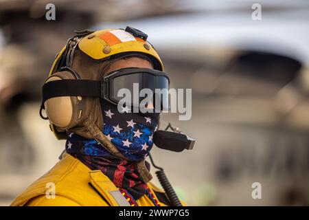 La U.S. Navy Aviation Boatswain's Mate (Handling) 1st Class Reyvin Olaes, nativo delle Filippine assegnato al bacino di trasporto anfibio USS Somerset (LPD 25), monitora un CH-53E Super Stallion collegato al Marine Medium Tiltrotor Squadron (VMM) 165 (rinforzato), 15th Marine Expeditionary Unit, durante le operazioni di volo di routine a bordo del Somerset mentre era in corso nel Mar delle Filippine, il 15 febbraio 2024. Somerset e gli elementi imbarcati della 15a MEU stanno conducendo operazioni di routine nella 7a flotta degli Stati Uniti. La 7th Fleet è la più grande flotta numerata della US Navy schierata in avanti Foto Stock